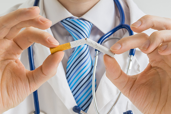 Doctor breaking cigarette in half